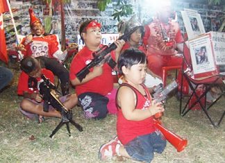Teaching them young - children of the red shirt movement play with toy guns during the fund-raising rally in Pattaya.